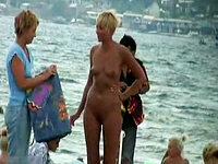 Absolutely naked female shamelessly demonstrating her nudity at the crowded beach!