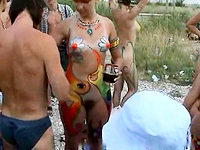 People are all nude on the beach getting the hot body art on smooth skin