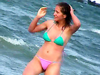 Thong swimwear and tiny bikini top. The girl demonstrates her body on the beach for voyeurs like me, and she's hot!