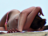 The topless bikini babe was lying on the beach almost falling asleep and paying no attention on guy with camera that was trying to shoot her goods