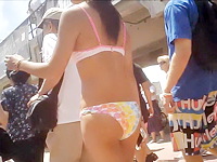 Cute girl looks pretty nice and sexy walking in nothing but the hot sexy bikini in the crowded street of the resort city