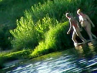 The nudist couple is on picnic enjoying the summer sun and hot lake water with the nude skin
