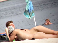 Hot nudist girls are on their bellies giving the cute naked butts to the warming up sun rays and enjoying the chatting